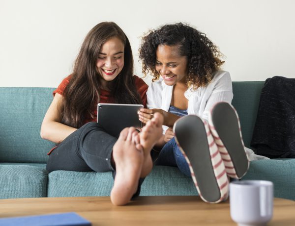 Two teen girls look at a tablet
